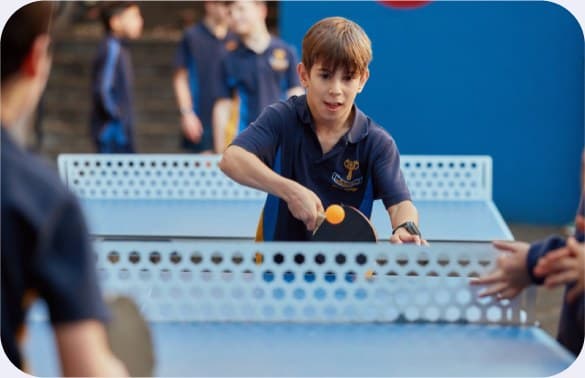A student returning a shot during a lunchtime table tennis game