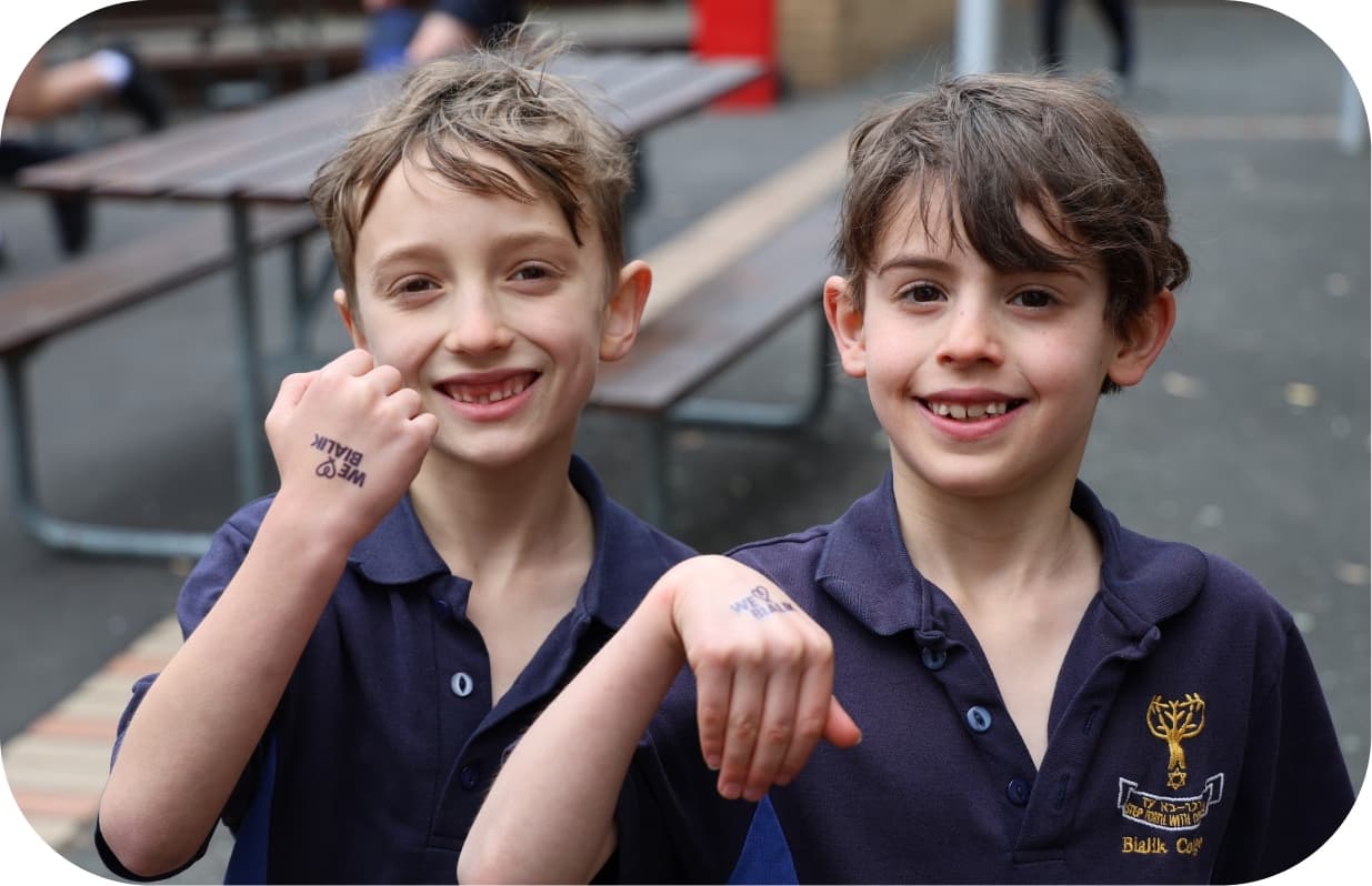 Two students showing off the temporary tattoos on their wrists
