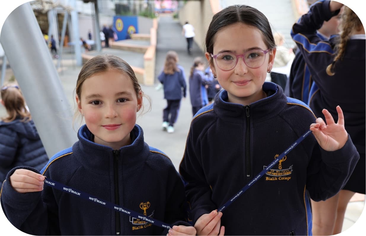 Two students holding up their Giving Day wristbands